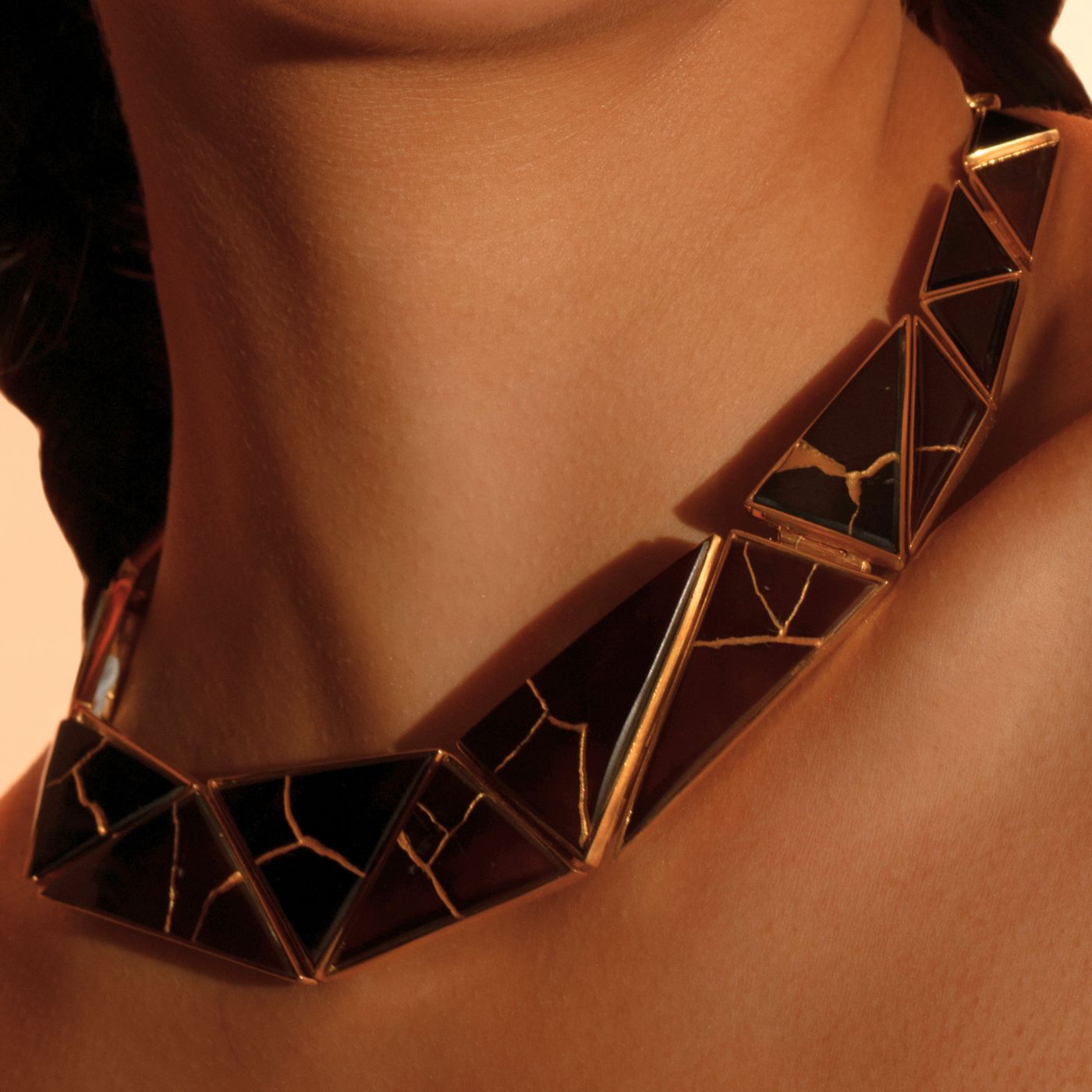 Model wearing sculptural Kintsugi collar necklace with black resin and gold vein inlay