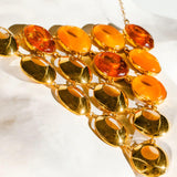 Close detail of triangular amber statement necklace with lab-grown amber and gold links