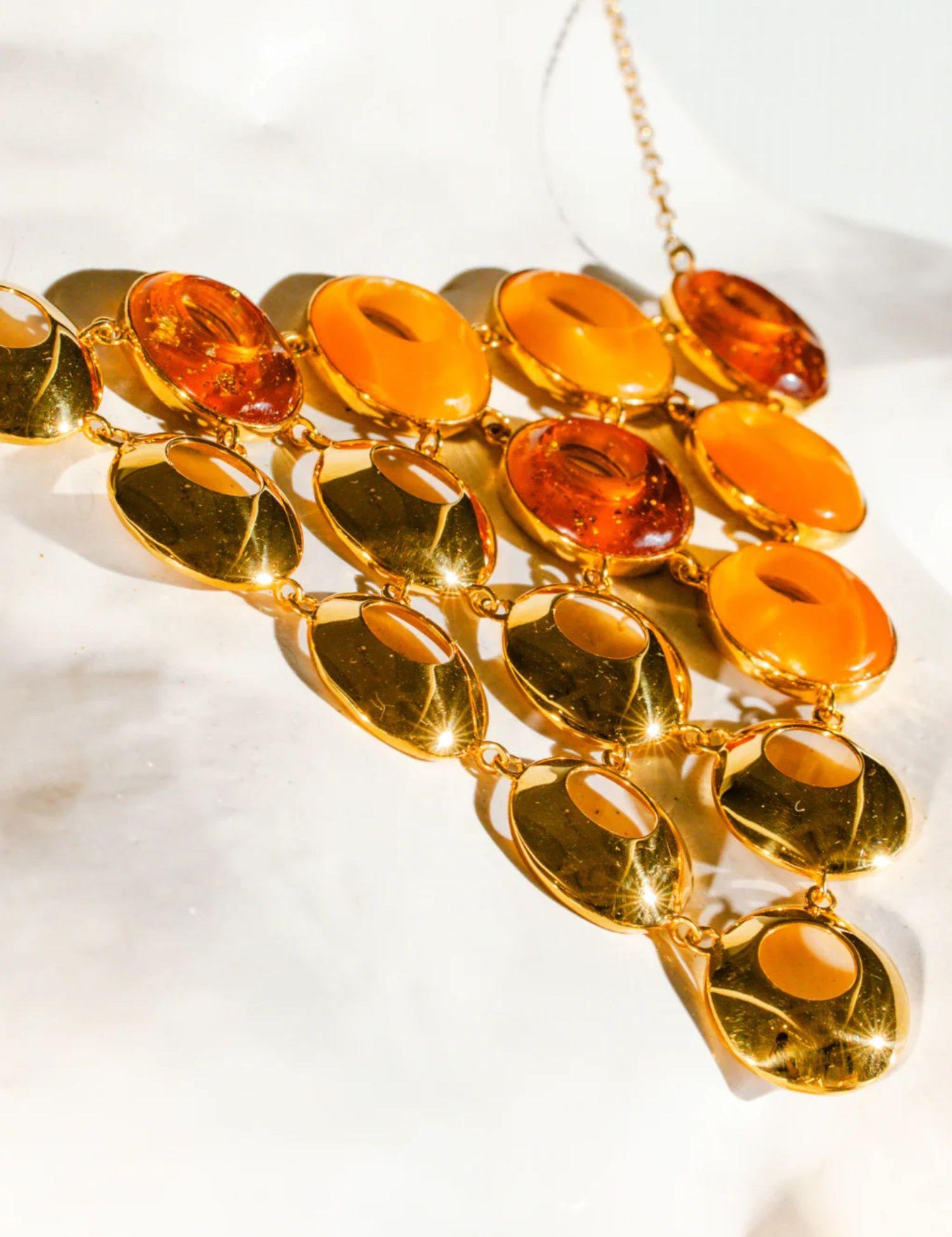 Close detail of triangular amber statement necklace with lab-grown amber and gold links