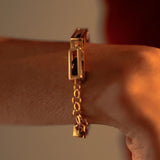 Close-up of gold Fill Me In bracelet worn on wrist with chain clasp detail