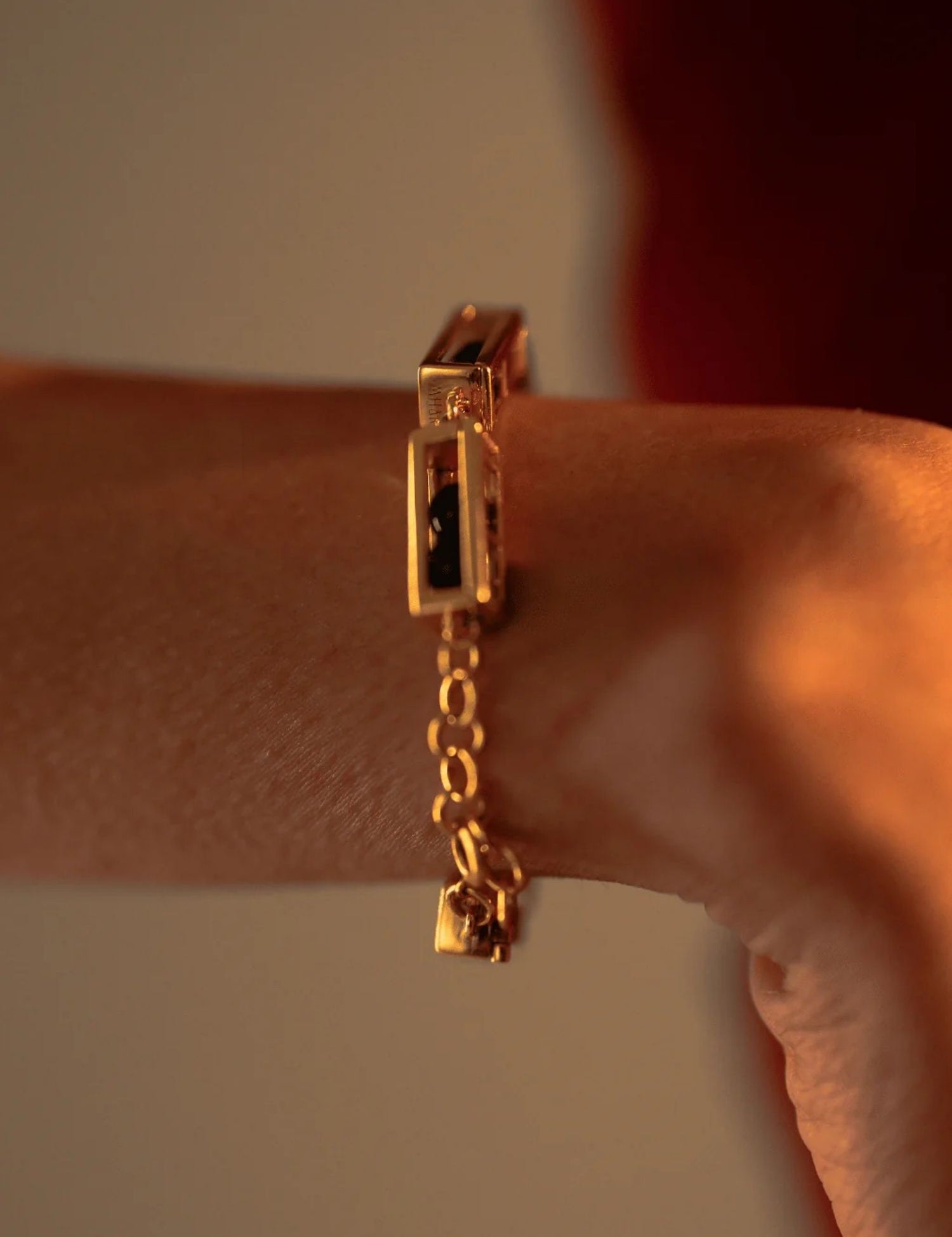 Close-up of gold Fill Me In bracelet worn on wrist with chain clasp detail