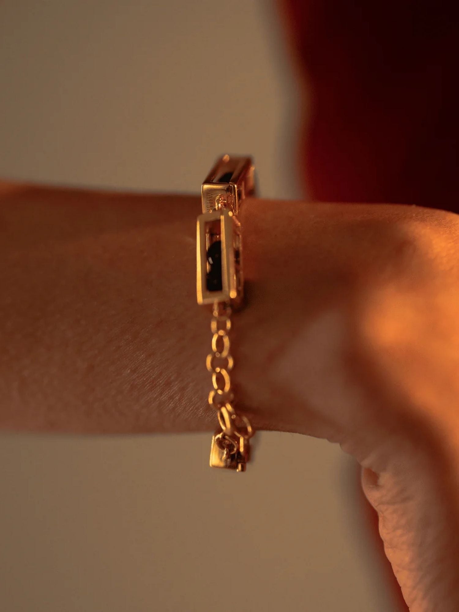 Close-up of gold Fill Me In bracelet worn on wrist with chain clasp detail