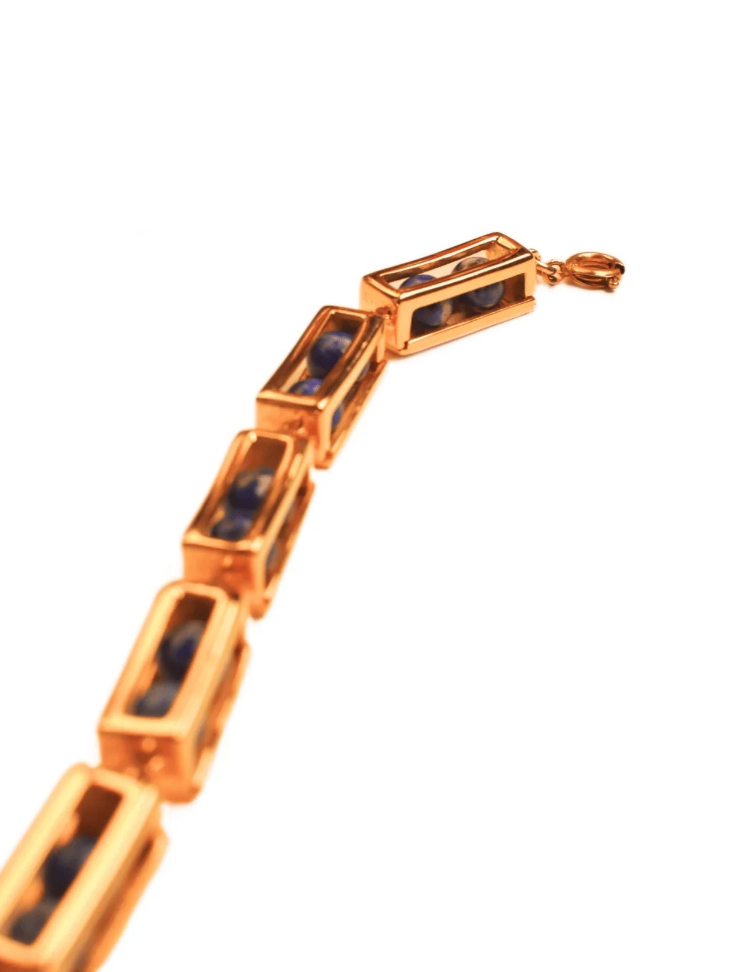 Angled product shot of gold box link bracelet with lapis lazuli beads