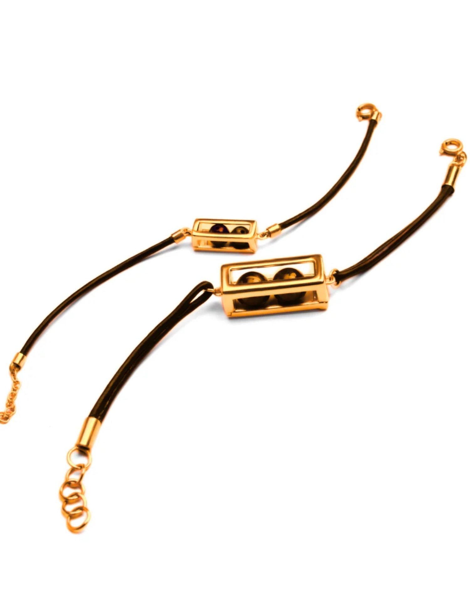 Gold box motif on dark leather cord bracelet with chain clasp on white