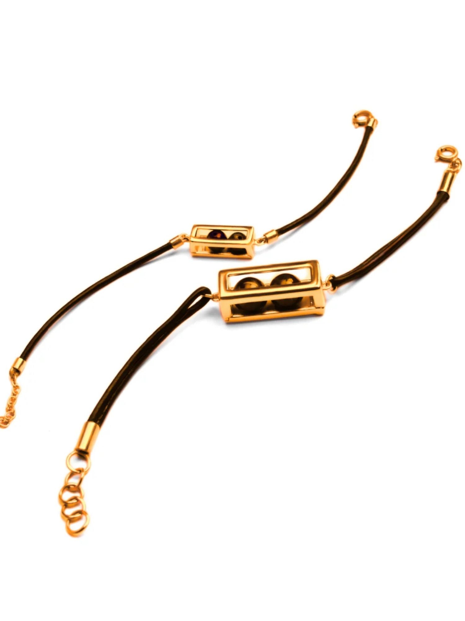 Gold box motif on dark leather cord bracelet with chain clasp on white