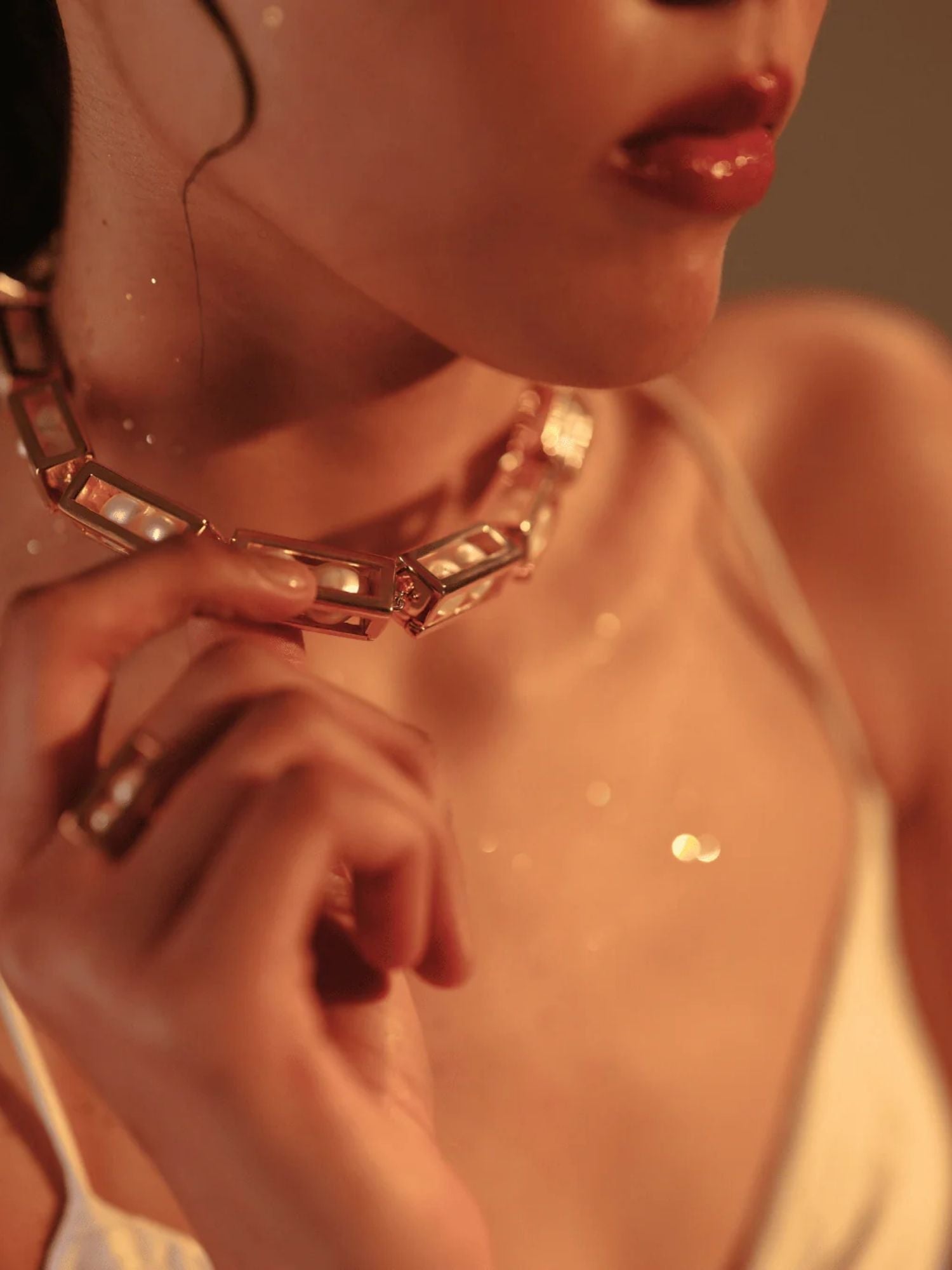 Model wearing large gold Fill Me In necklace, collarbone close-up in warm tones
