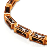 Close-up of open gold box link showing interchangeable bead mechanism