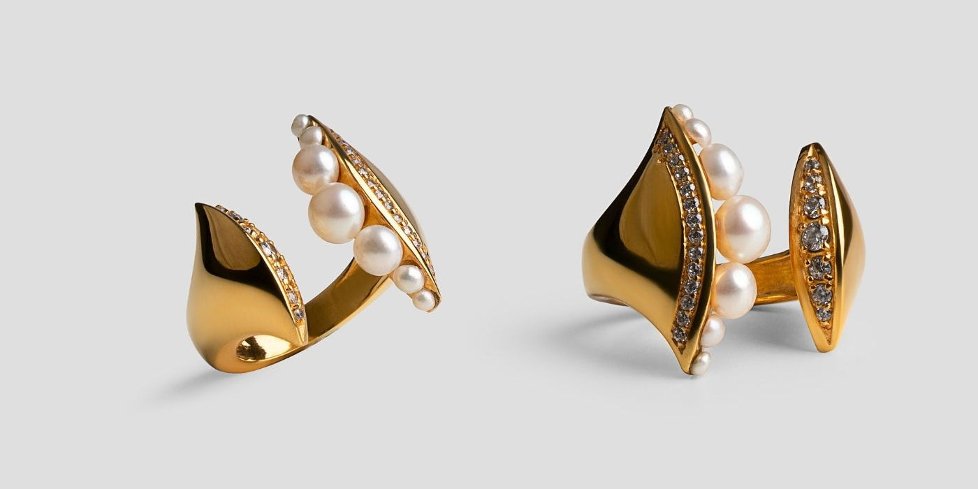 Sculptural gold ring set with graduated pearls and pavé zircons on grey, MHARI gifting collection.