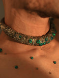 Green opal hasli necklace on male model's collarbone in warm close-up
