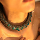 Model wearing green opal hasli necklace close to collarbone in warm light