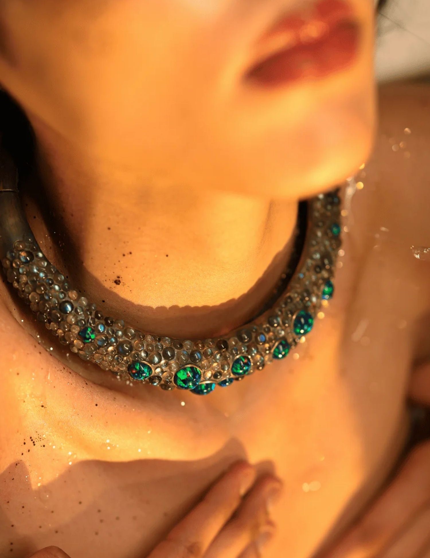 Model wearing green opal hasli necklace close to collarbone in warm light