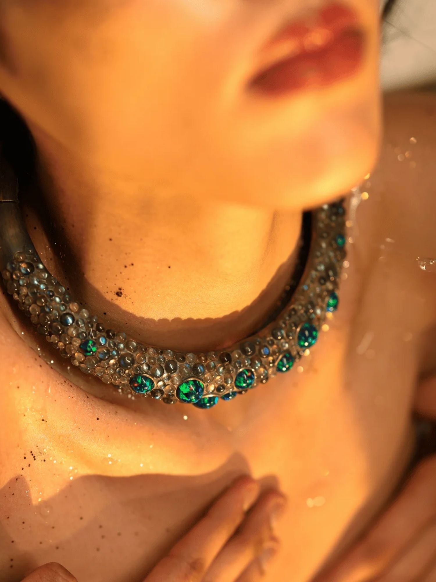 Model wearing green opal hasli necklace close to collarbone in warm light
