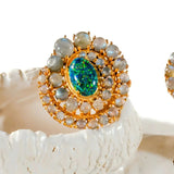 Close-up of green opal spiral earrings on white prop showing stone arrangement