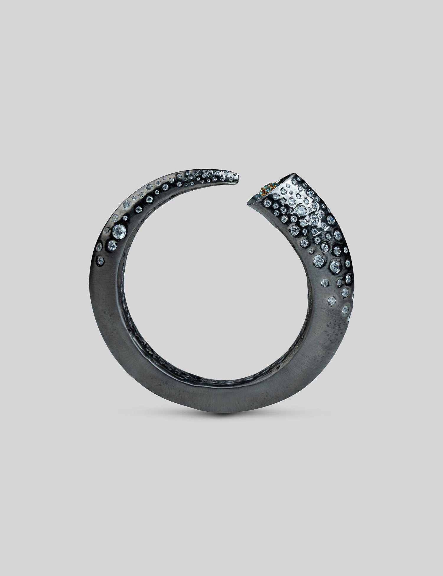 Irodori black oxidised silver bangle with zircon cluster tip detail, full form on neutral background.