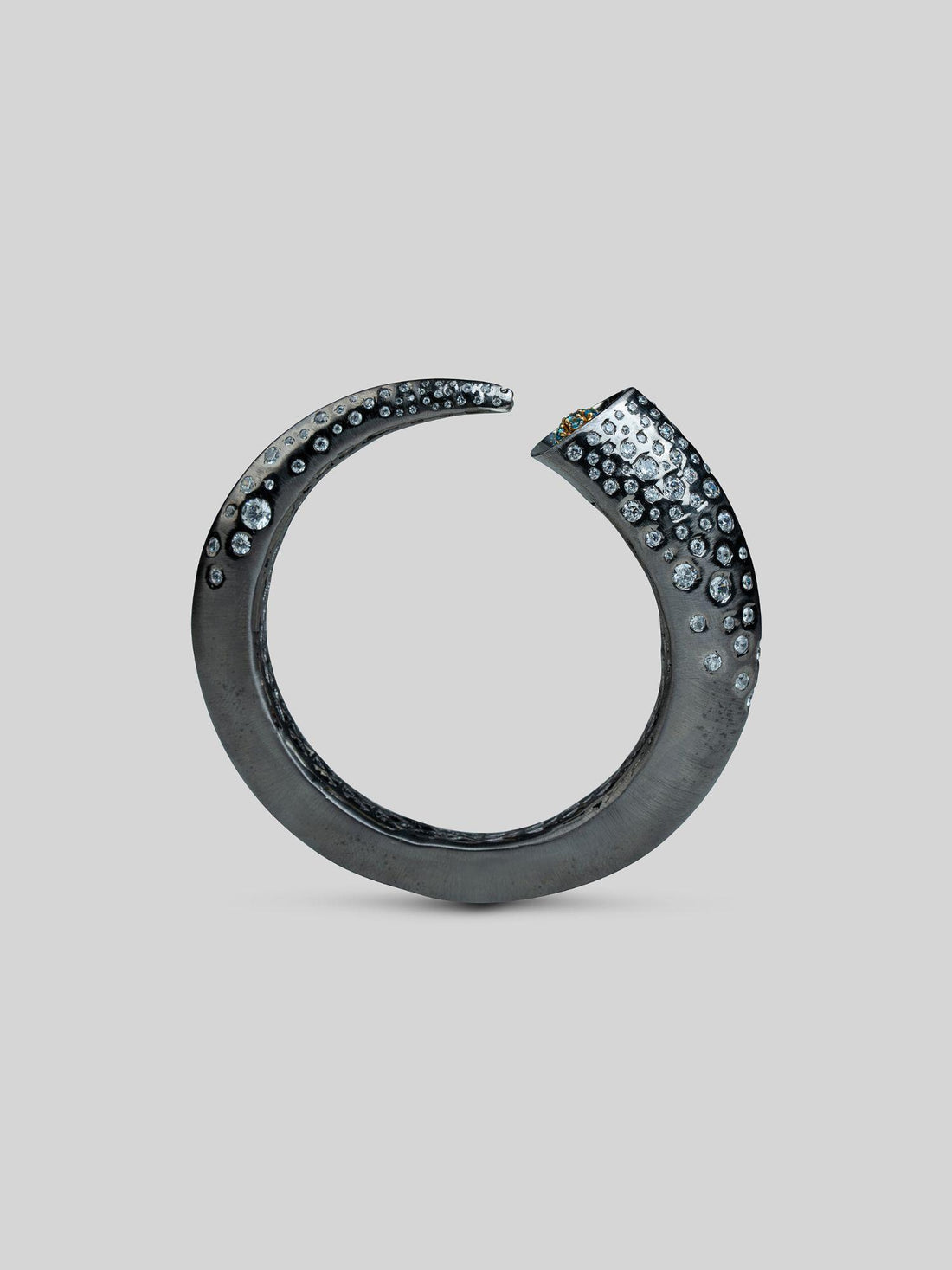 Irodori black oxidised silver bangle with zircon cluster tip detail, full form on neutral background.