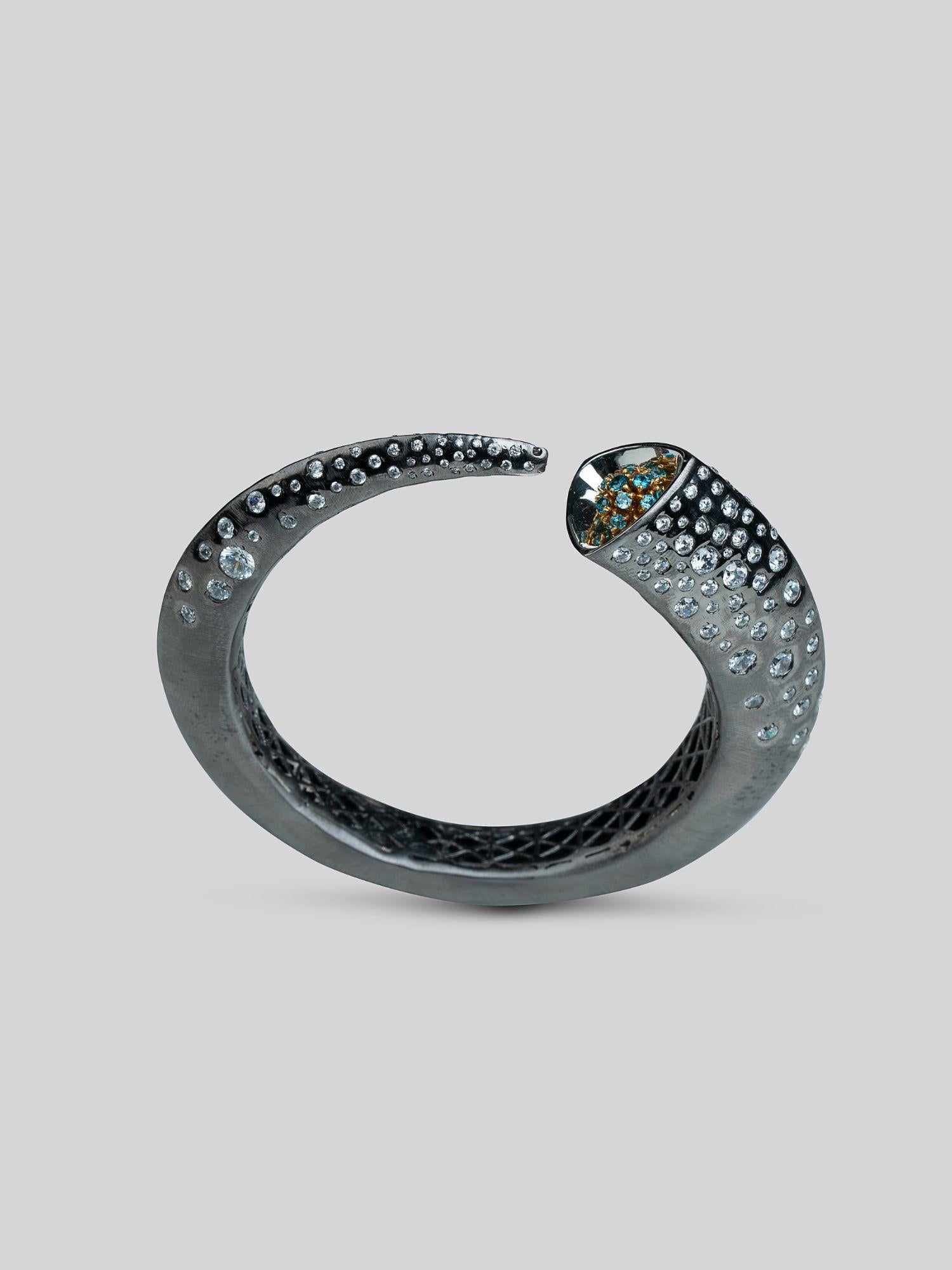 Close product shot of Irodori bangle showing teal zircon stone tip set in black oxidised silver.