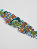 Close detail of Irodori choker showing amber orange and teal zircon cluster motifs in polished silver.
