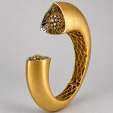 Close angled shot of Irodori gold cuff showing handcrafted lattice interior and CZ flower motif tip detail.