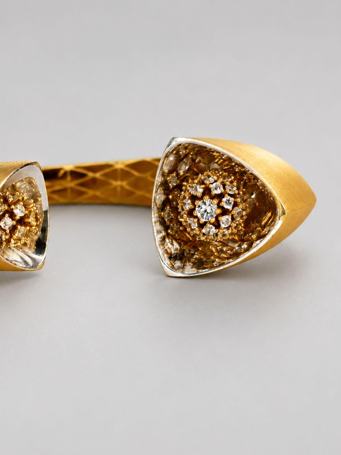 Close angled shot of Irodori gold cuff showing handcrafted lattice interior and CZ flower motif tip detail.