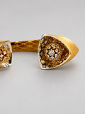Extreme close-up of Irodori cuff motif tip showing CZ-set double flower detail in 24k gold.