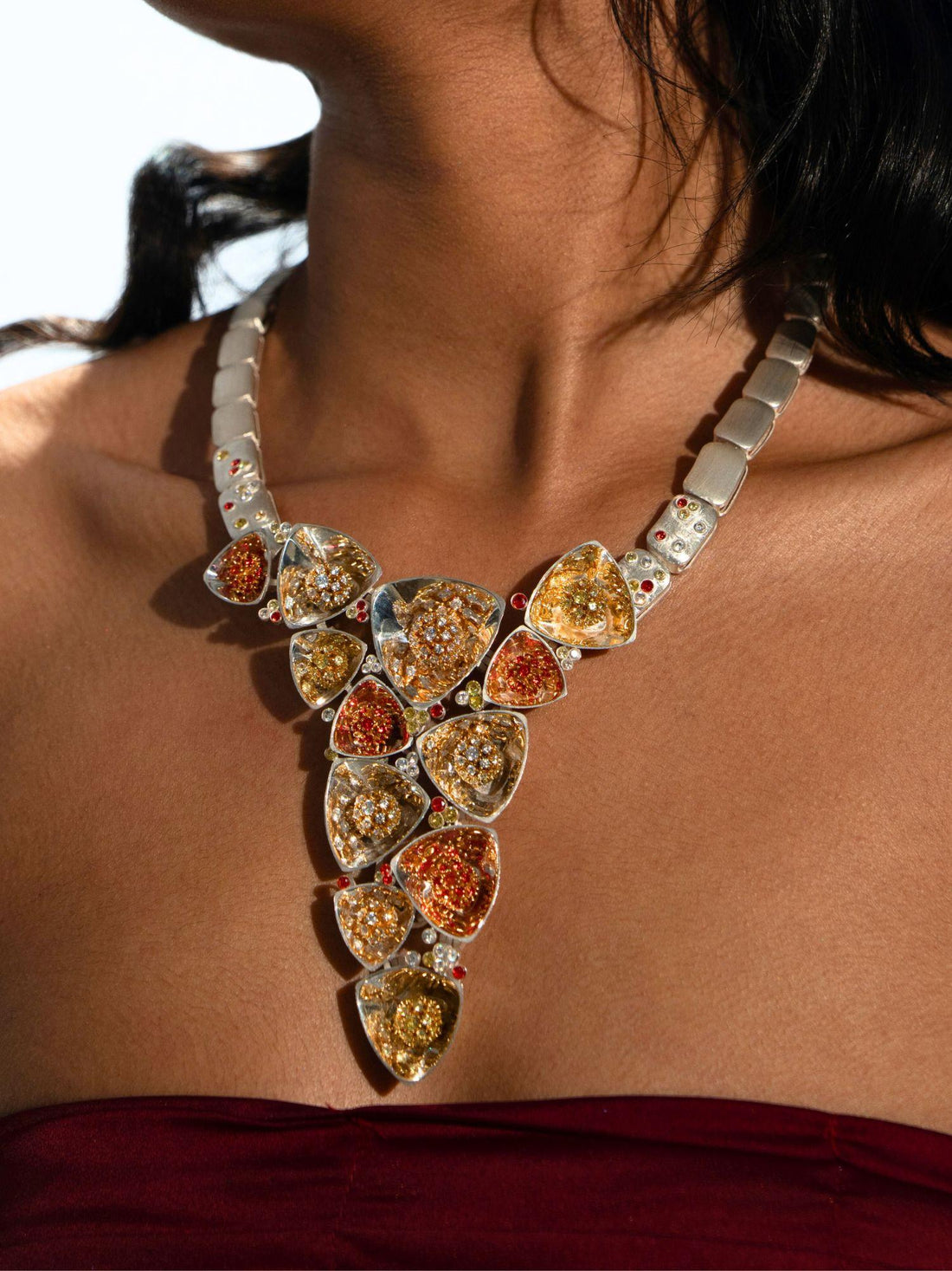 Irodori long statement necklace with mixed zircon cluster pendants in silver on neutral background.