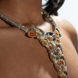 Side close-up of Irodori silver statement necklace with amber zircon clusters worn on model's neck.