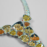Close product shot of Irodori necklace showing amber and orange zircon cluster motifs in polished silver.