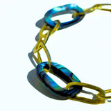 Angled product shot of bold abalone and gold oval link chain bracelet