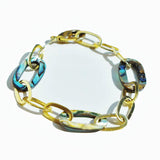 Abalone and gold link chain bracelet on white background, blue-green stones