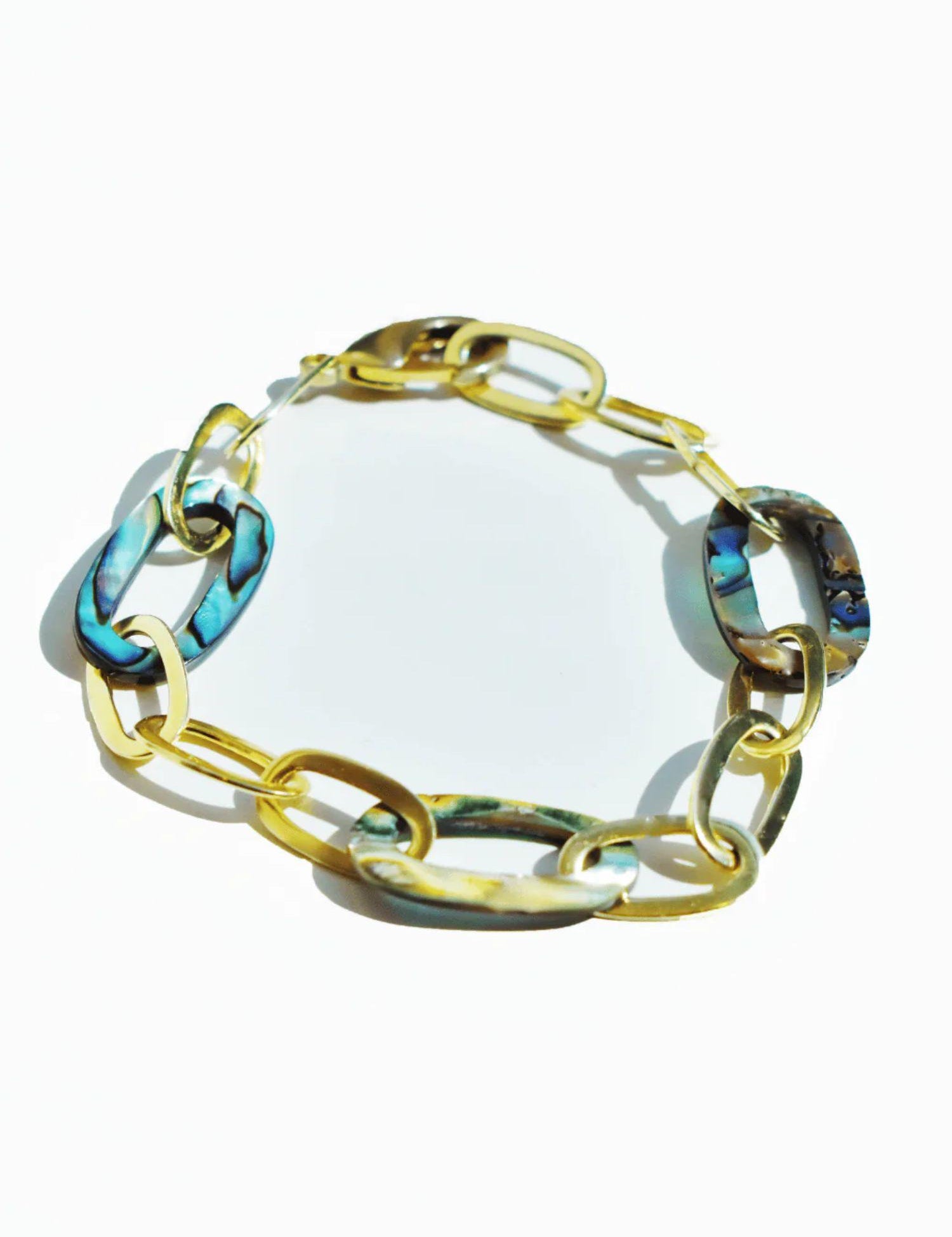 Abalone and gold link chain bracelet on white background, blue-green stones