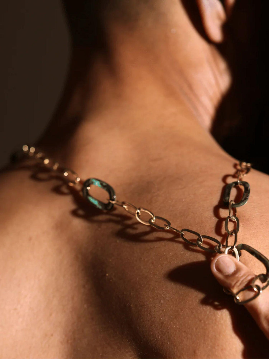 Gold link chain necklace with abalone stone set and small earrings on white