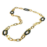 Gold oval link chain necklace with abalone stone links on white background