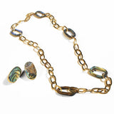 Gold link chain necklace with abalone stones and matching earrings on white