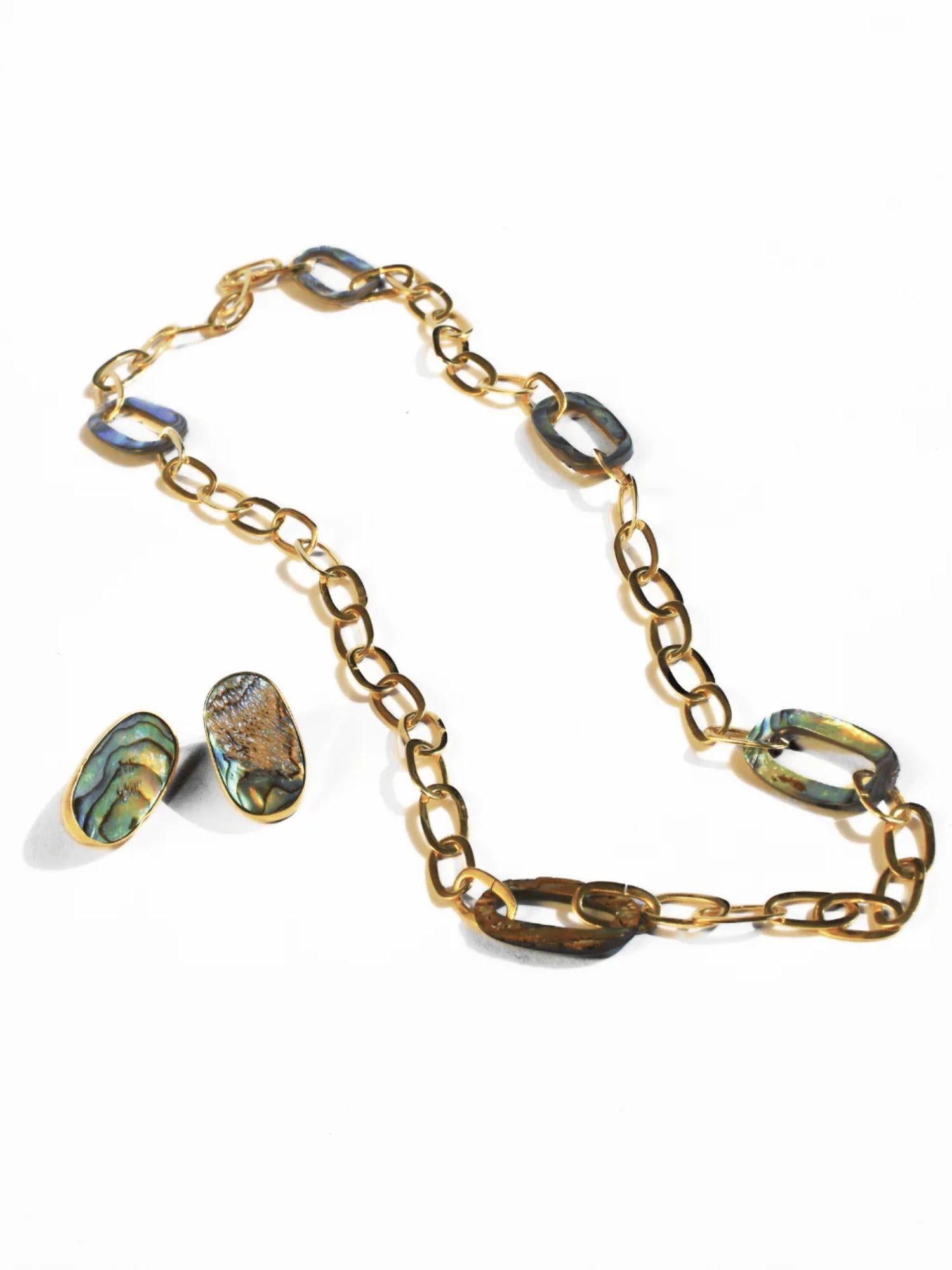 Gold link chain necklace with abalone stones and matching earrings on white