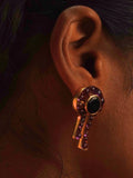 Kōmon keyhole statement earring with black spinel centre and amethyst worn close to ear on model.