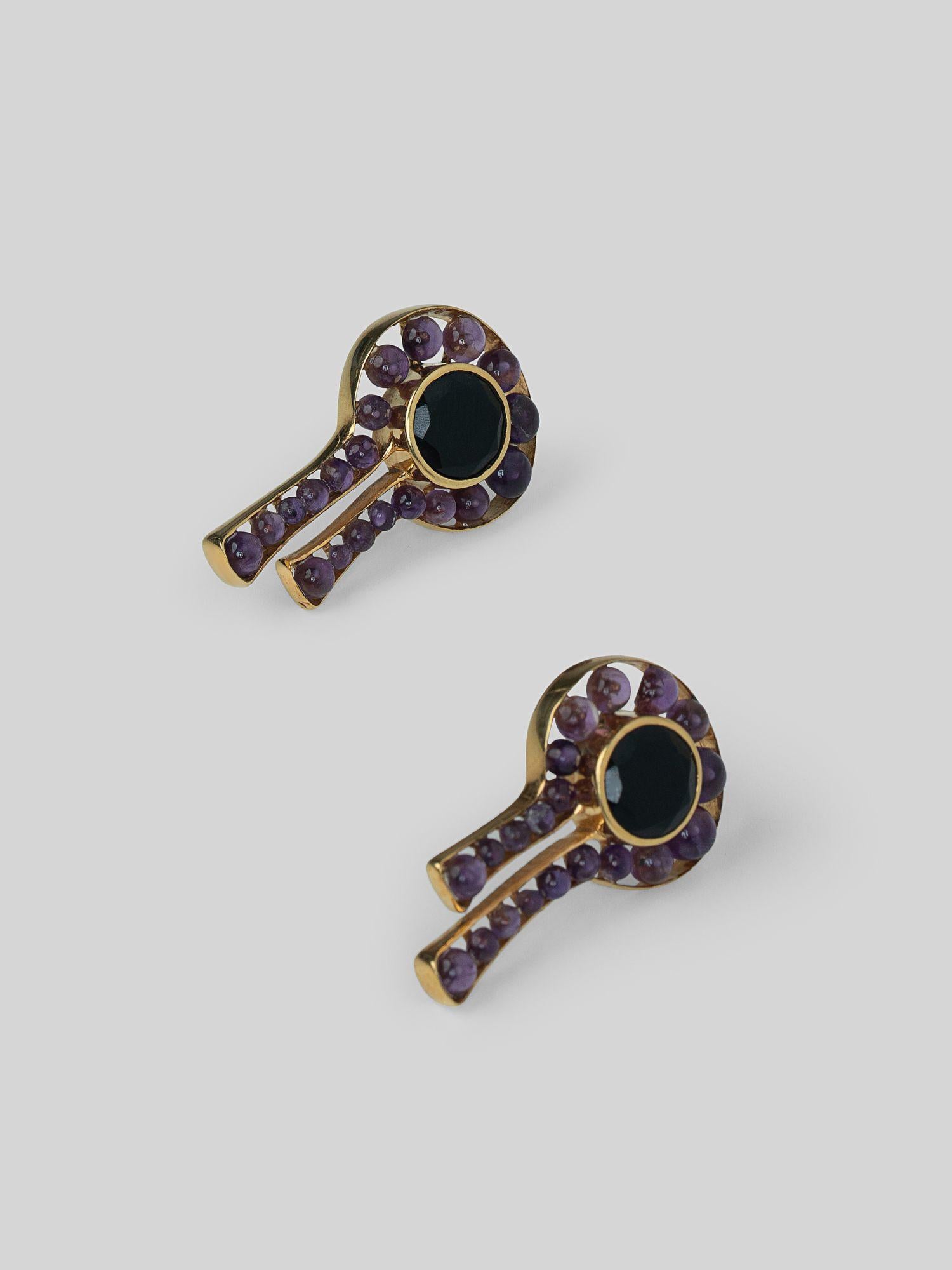 Angled product shot of Kōmon keyhole earrings showing circular spinel form and drop detail in gold.