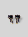 Kōmon keyhole stud earrings with black spinel centre and amethyst border in gold on neutral background.