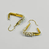 Maré Pearl Hanger earrings with natural pearl beads on triangular gold form in 24k gold on neutral background.