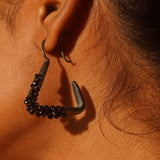 Maré black rhodium hanger earring with natural spinel cluster worn in profile close-up on model.