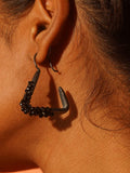 Maré black rhodium hanger earring with natural spinel cluster worn in profile close-up on model.