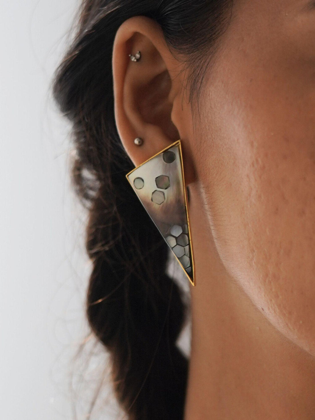Triangular Mosaic statement earrings with abalone and mother of pearl on a white background.