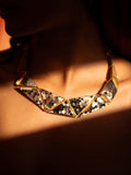Mosaic mother of pearl statement necklace worn on the collarbone in warm directional light.