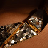 Extreme close-up of Mosaic necklace on model showing beehive abalone tile play in 24k gold.