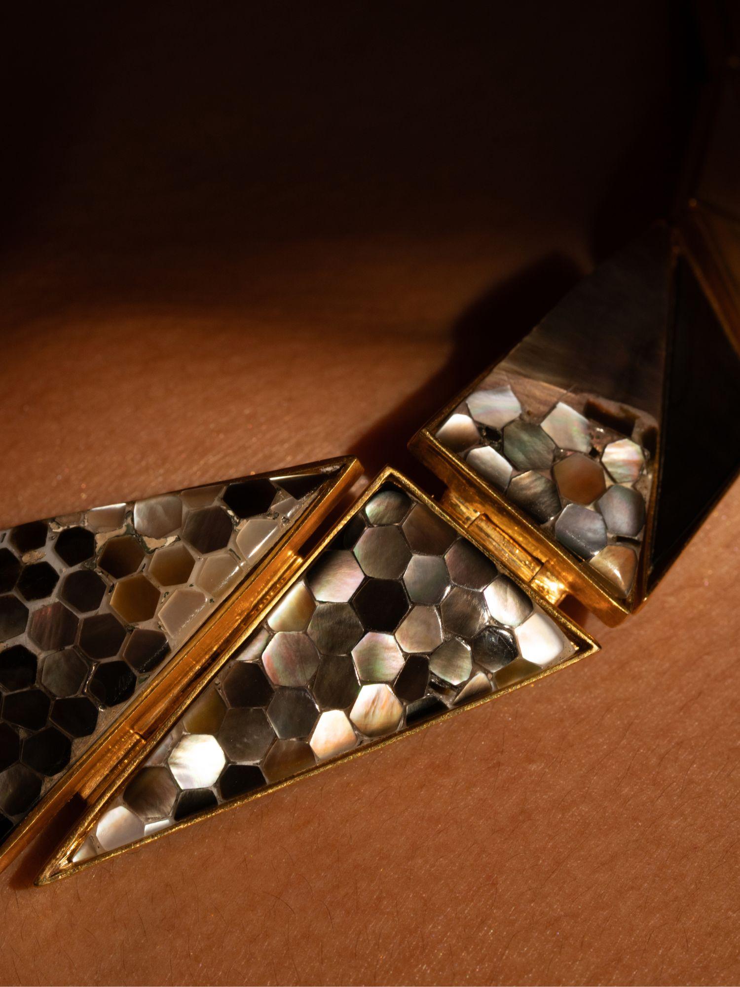 Extreme close-up of Mosaic necklace on model showing beehive abalone tile play in 24k gold.