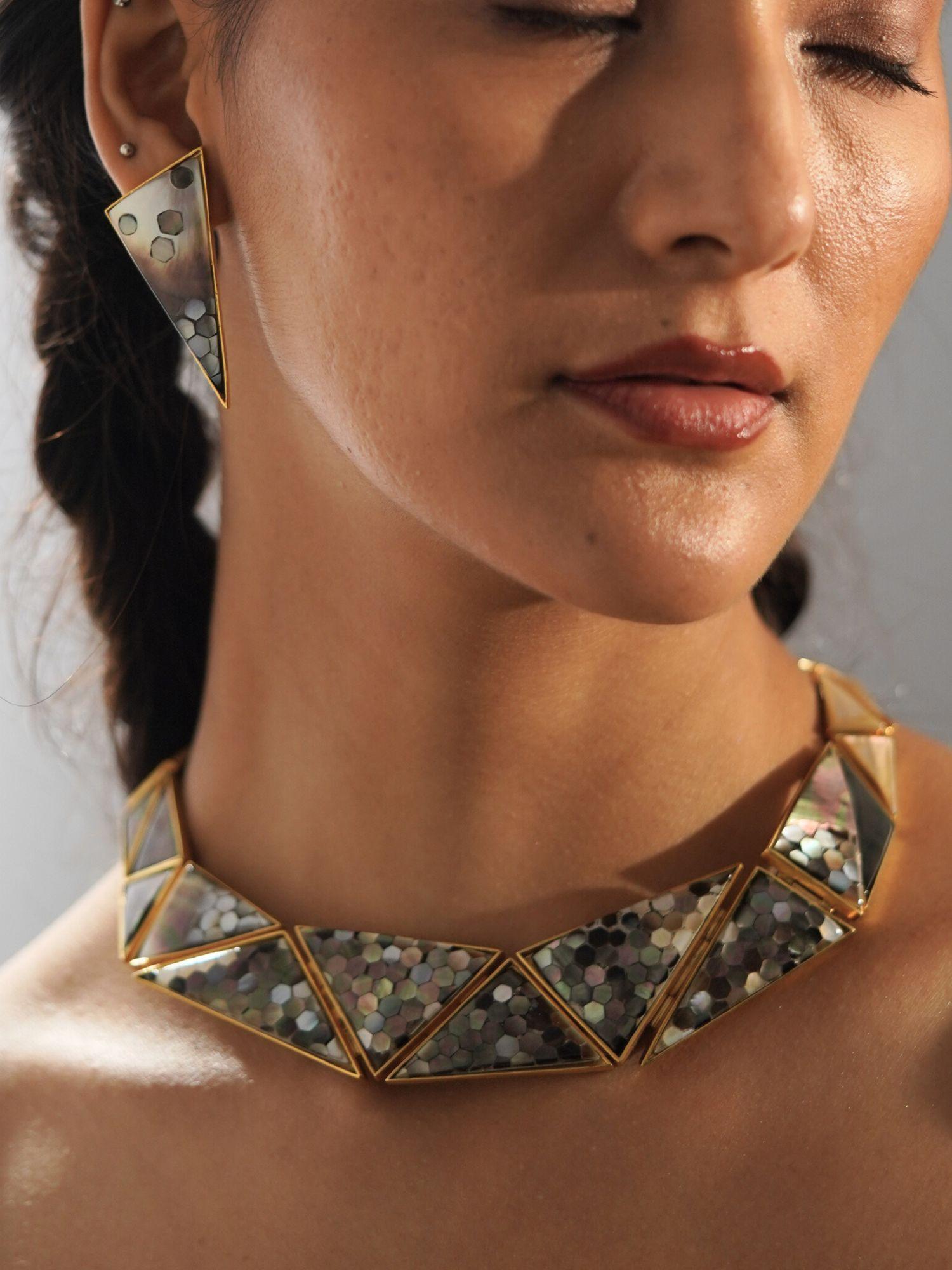Model wearing Mosaic abalone necklace front-on, hexagon tiles catching light in editorial portrait.
