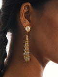 Close profile of Neris pearl and gold shell drop earring worn on model against clean background.