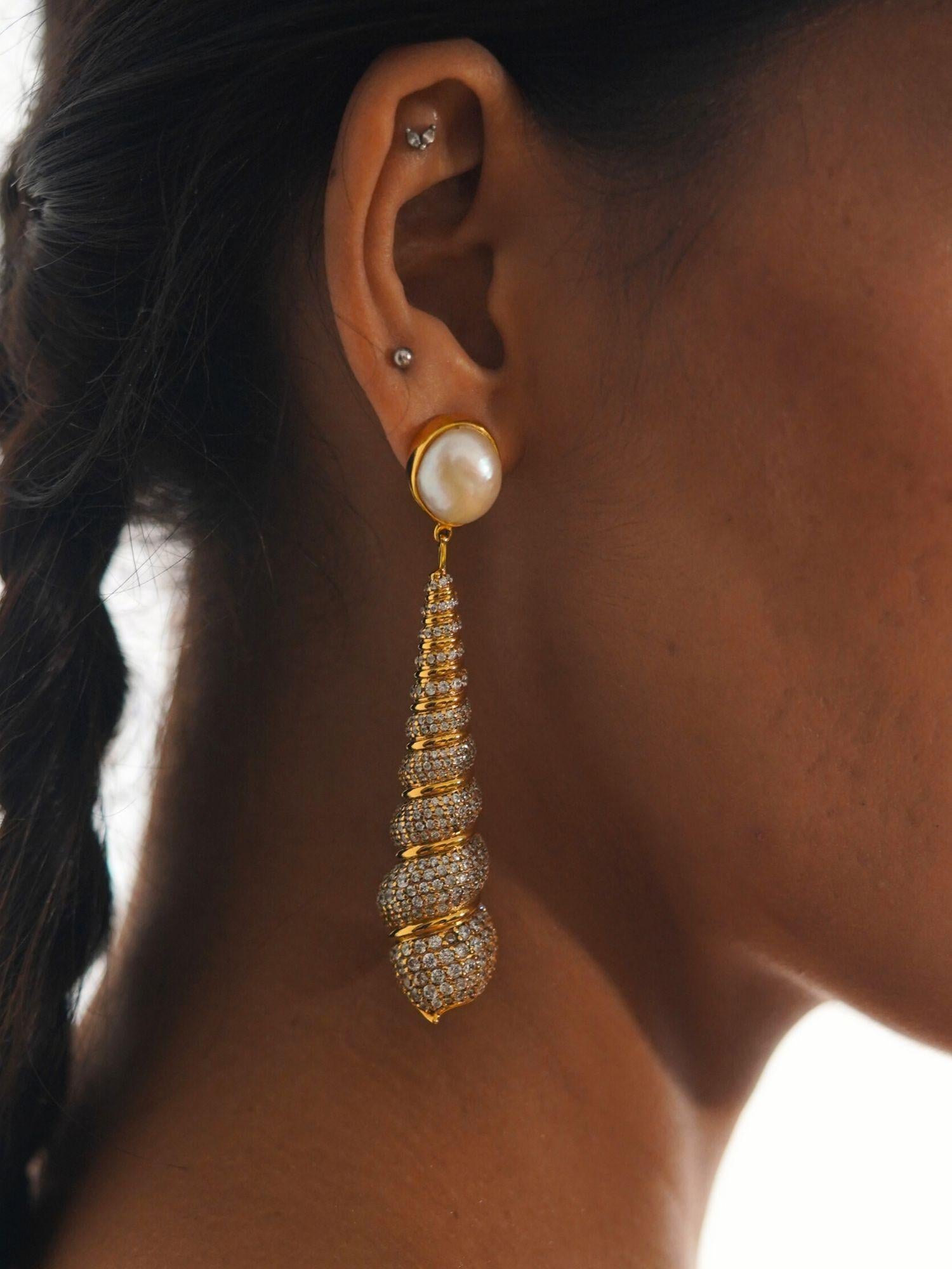 Close profile of Neris pearl and gold shell drop earring worn on model against clean background.
