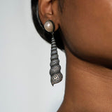 Close profile of Neris pearl and oxidised silver shell drop statement earring on model.