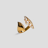 Side view of Noira pearl ring showing sculptural gold form with natural pearl detail.