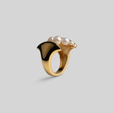 Three-quarter product shot of Noira natural pearl and gold sculptural ring on neutral background.